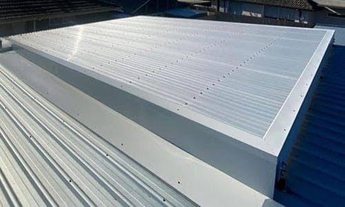 Metal roof flashings around a raised roof well