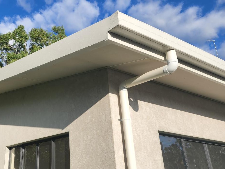 Square fascia gutter and PVC downpipe on a rendered Queensland home